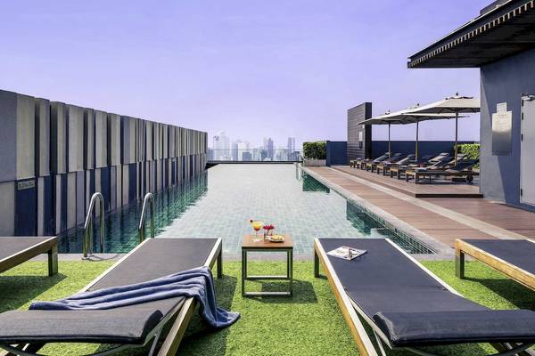 Poolterrasse des Mercure Bangkok Siam mit Sonnenliegen und Getränken