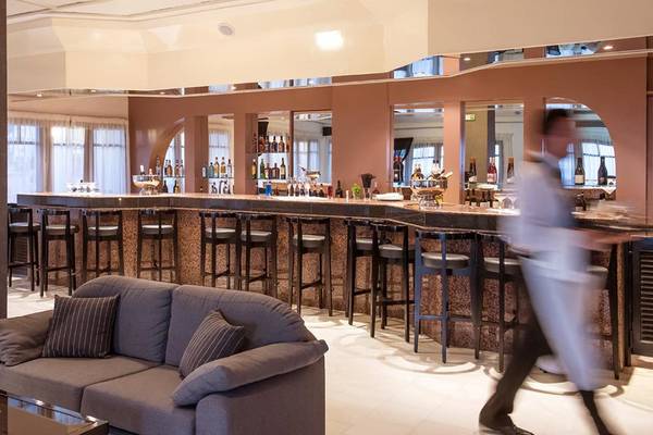 Barbereich des Hersonissos Palace Hotels mit Barhockern, einer Couch und einem Mitarbeiter