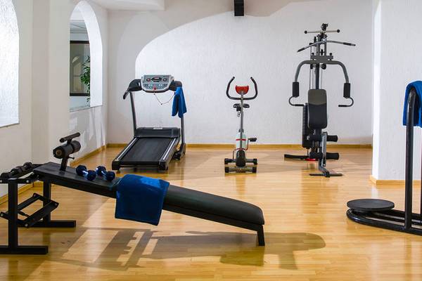 Fitnessraum im Hersonissos Palace Hotel mit Laufband, Hantelbank und anderen Geräten.