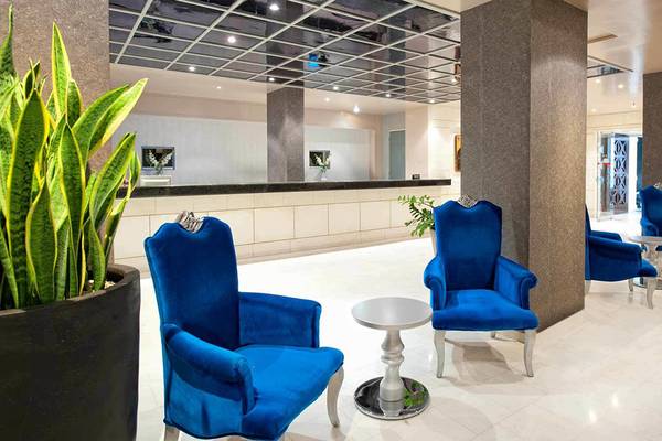 Lobby des Hersonissos Palace Hotels mit blauen Stühlen und weißen Tischen.
