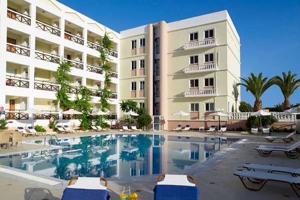 Außenbereich des Hersonissos Palace Hotels mit Swimmingpool und Loungeliegen.