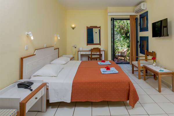 Hotelzimmer im Dessole Dolphin Bay Resort mit Doppelbett, Schreibtisch und Balkon.