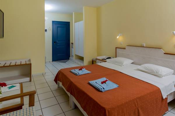 Doppelzimmer im Dessole Dolphin Bay Resort mit zwei Betten und gelben Wänden.