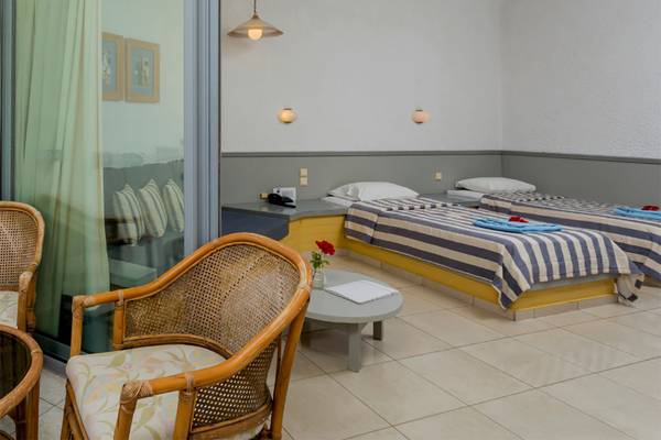 Doppelzimmer-Innenansicht im Dessole Dolphin Bay Resort mit zwei Betten, Tisch und Stühlen.