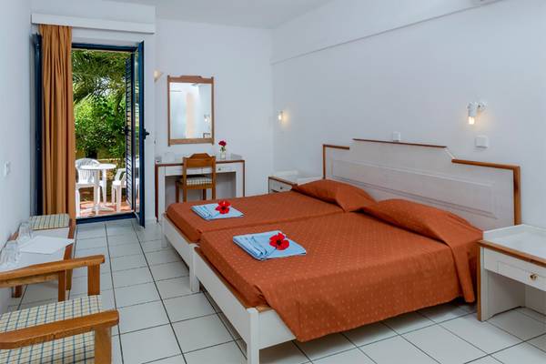 Doppelzimmer-Innenansicht des Dessole Dolphin Bay Resorts mit zwei Betten, Tisch und Stuhl.