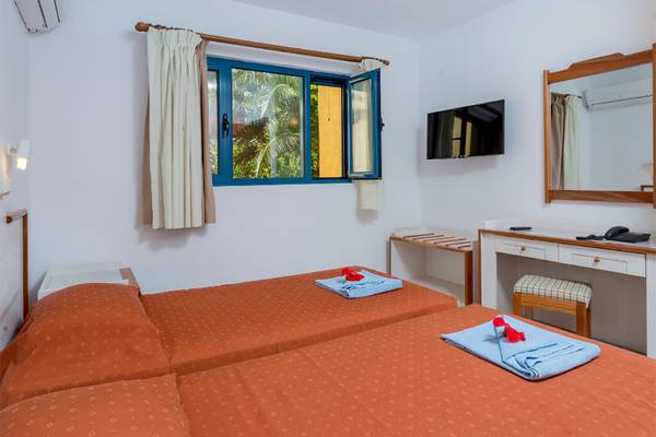 Doppelzimmer im Dessole Dolphin Bay Resort mit zwei Betten und Blick aus dem Fenster.