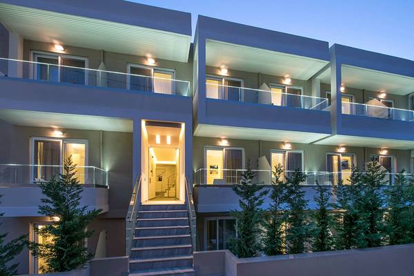 Außenansicht des Odyssia Beach Hotels bei Nacht mit beleuchteten Balkonen und Treppen