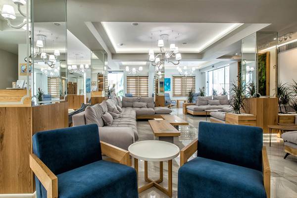 Lobby des Odyssia Beach Hotels mit modernen Möbeln, hellen Farben und großen Spiegeln.
