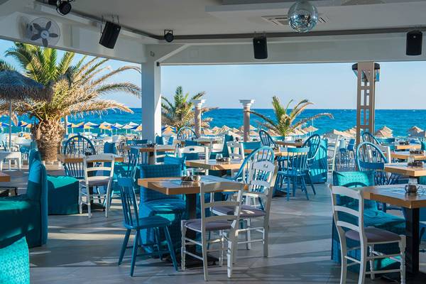Innenansicht des Restaurants im Odyssia Beach Hotel mit Blick auf den Ozean.