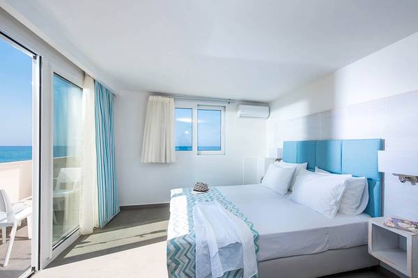 Ein modernes Zimmer im Odyssia Beach Hotel mit Blick auf das Meer und einer Terrasse.