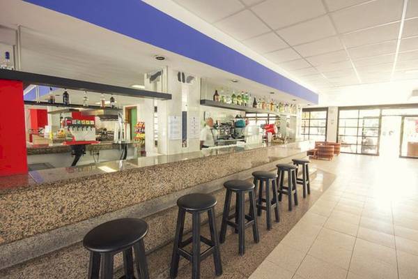 Barbereich des Azuline Hotel Mar Amantis mit Theke, Stühlen und offenen Türen.