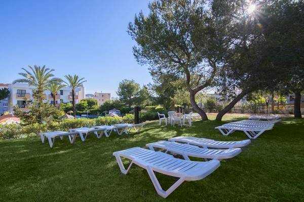 Gartenbereich des Azuline Hotel Mar Amantis I & II mit weißen Liegen auf grünem Rasen.