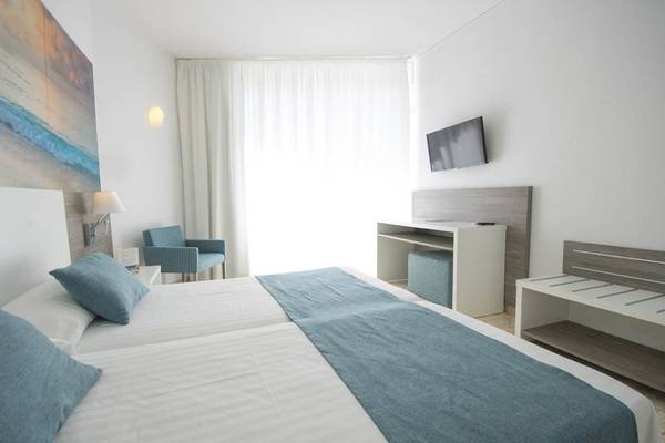 Doppelbettzimmer im Azuline Hotel Mar Amantis mit Fernseher, Stuhl und Schreibtisch.