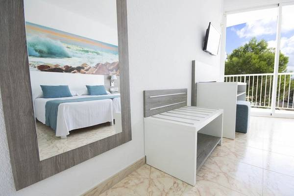 Innenansicht eines Zimmers im Azuline Hotel Mar Amantis mit einem Bett, Spiegel und Balkon.