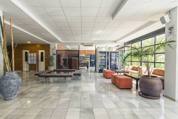Lobby des Azuline Hotel Mar Amantis mit weißen Fliesen, großen Vasen und Sitzgelegenheiten.