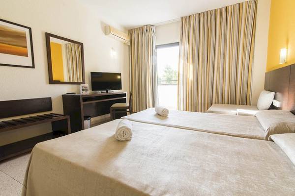Hotelzimmer im Azuline Hotel Mar Amantis mit zwei Betten, Fernseher und Schreibtisch.