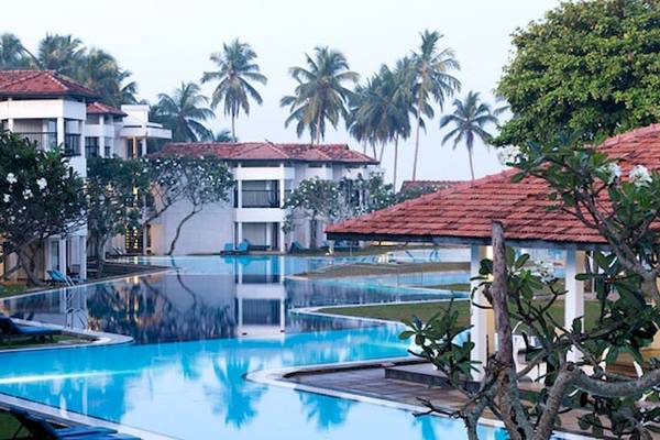 Außenansicht des Club Hotel Dolphin mit großem Swimmingpool und tropischen Bäumen.