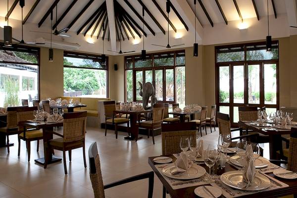 Innenansicht des Restaurants im Club Hotel Dolphin mit gedeckten Tischen und Stühlen.