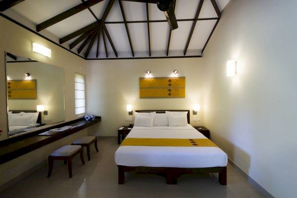 Schlafzimmer im Club Hotel Dolphin mit Doppelbett, Nachttischen und Wanddekoration.