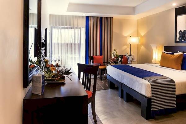 Schlafzimmer im Club Hotel Dolphin mit Doppelbett, Dekor und Möbeln.