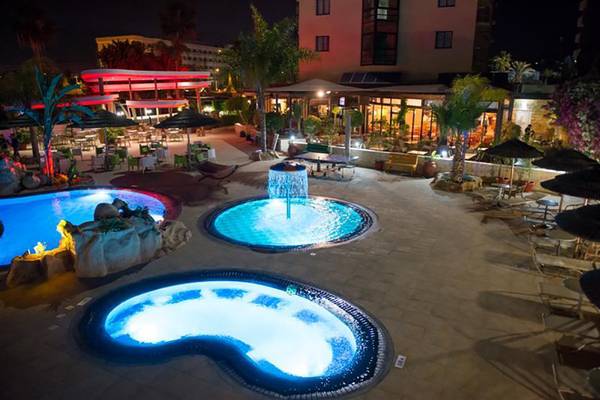 Nachtansicht des Stamatia Hotels mit beleuchteten Swimmingpools und Sitzbereichen.