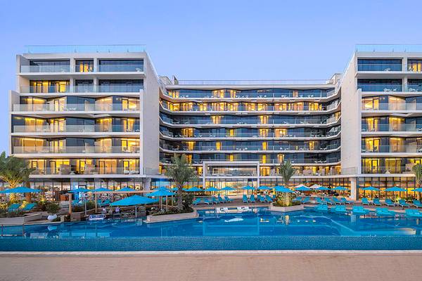 Außenansicht des Retreat Palm Dubai MGallery by Sofitel Hotels mit Swimmingpool und Sonnenschirmen