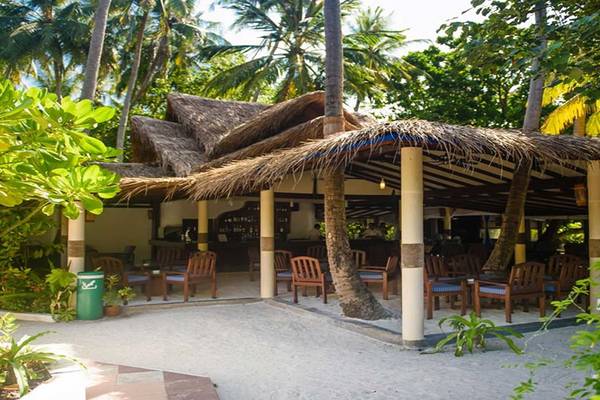 Außenbereich des Biyadhoo Island Resorts mit schattiger Bestuhlung und Palmen