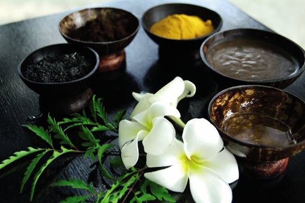 Spa-Produkte auf dem Biyadhoo Island Resort, darunter Blumen und verschiedene Paste.