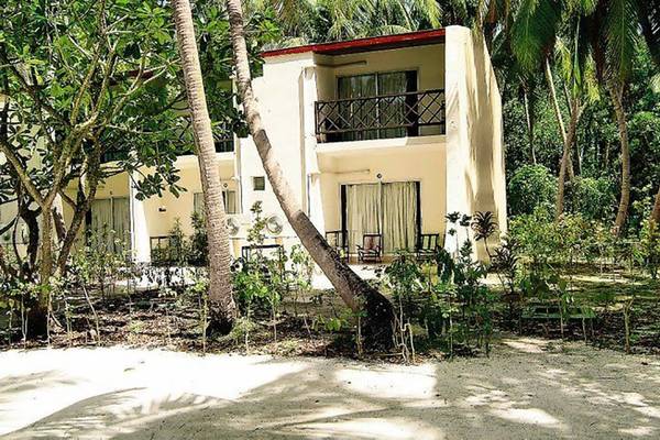 Außenansicht des Biyadhoo Island Resorts mit Balkon und umgebenden Palmen