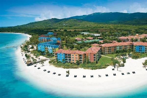 Luftaufnahme des Sandals Whitehouse European Village & Spa Hotels mit farbigen Gebäuden und Strand