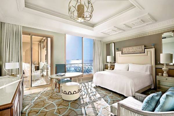 Innenansicht der Suite im Waldorf Astoria Ras Al Khaimah mit großem Bett und Meerblick