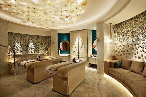 Spa-Bereich im Waldorf Astoria Ras Al Khaimah mit zwei Behandlungsliegen und einer Couch.