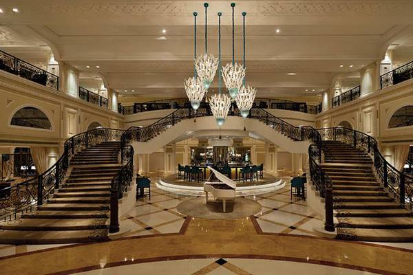Innenansicht des Waldorf Astoria Ras Al Khaimah Hotels mit einer weißen Flügel und zwei Treppenhäusern.