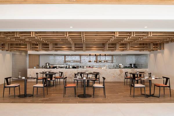 Innenansicht des Restaurants im Mitsis Norida Beach Hotel mit Holzboden und modernen Möbeln.