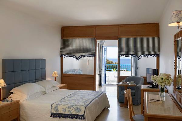 Schlafzimmer im Mitsis Norida Beach Hotel mit Blick auf das Meer und Balkon.