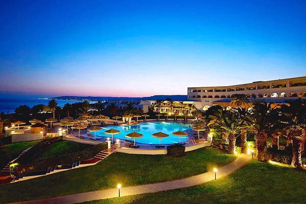 Abendaufnahme des Mitsis Norida Beach Hotels mit Swimmingpool und Meerblick.