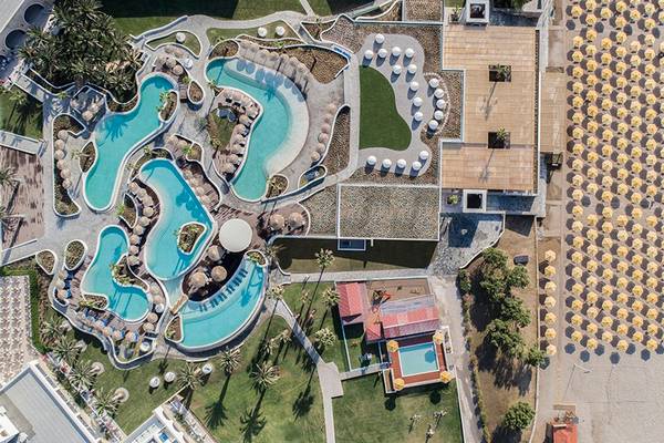 Luftaufnahme des Mitsis Norida Beach Hotels mit Swimmingpools, Sonnenschirmen und Strand