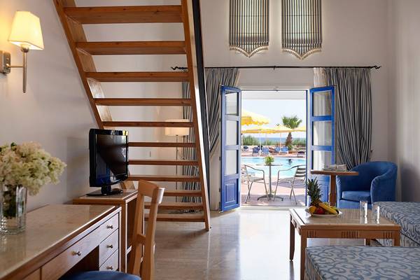 Innenansicht eines Zimmers im Mitsis Norida Beach Hotel mit Blick auf einen Swimmingpool.