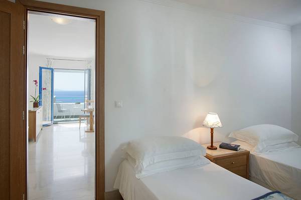 Zimmer im Mitsis Norida Beach Hotel mit Blick auf das Meer von einer Terrasse.