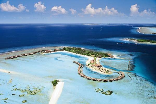 Luftaufnahme des Cinnamon Dhonveli Maldives mit blauem Wasser und weißen Sandstränden.