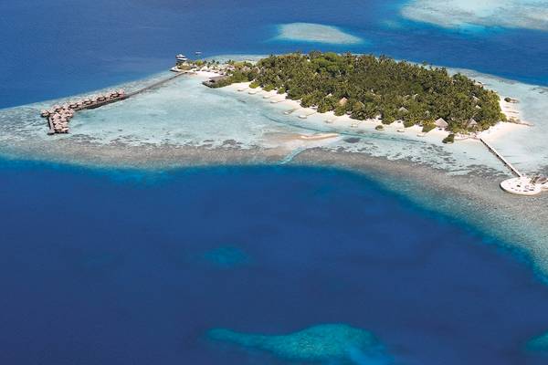 Luftaufnahme des Nika Island Resorts und Spa mit Bungalows und Steg am Riff