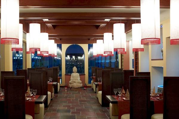 Innenansicht des Restaurants im Atrium Prestige Thalasso Spa Resort & Villas mit Buddha-Statue, roten Ziegelböden und hängenden Laternen.