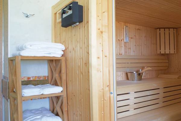 Sauna im Atrium Prestige Thalasso Spa Resort & Villas mit Holzwänden, Bänken und einem Eimer.
