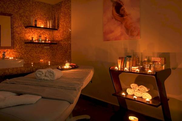 Behandlungsraum im Atrium Prestige Thalasso Spa Resort & Villas mit Massagetisch, Kerzen und Pflegeprodukten.