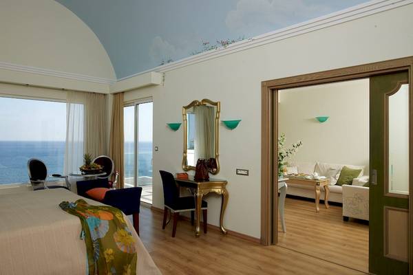 Eine Hotelsuite mit Blick auf das Meer und einer möblierten Terrasse.