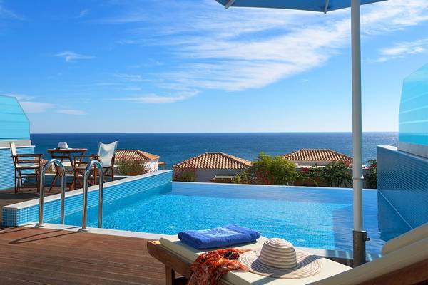 Poolbereich des Atrium Prestige Thalasso Spa Resorts mit Meerblick und Sonnenschirm.