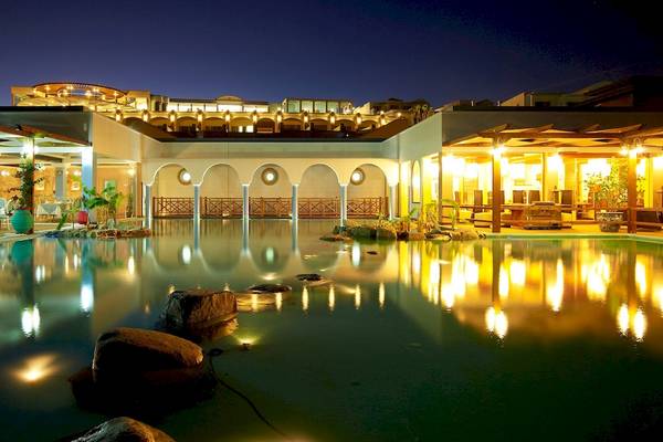 Nachtansicht des Atrium Prestige Thalasso Spa Resorts mit Pool, beleuchteten Gebäuden und Garten.
