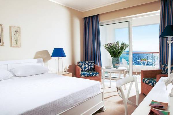 Innenansicht eines Hotelzimmers im Grecotel La Riviera & Aqua Park mit Blick auf das Meer.