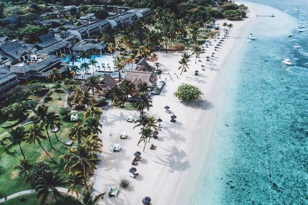 Luftaufnahme des Sofitel Mauritius L'Imperial Resorts und Spas mit Blick auf den Strand, Palmen und Wasser.