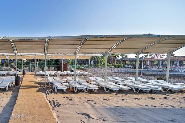 Strand mit vielen Liegestühlen unter Sonnenschirmen im Saturn Palace Resort